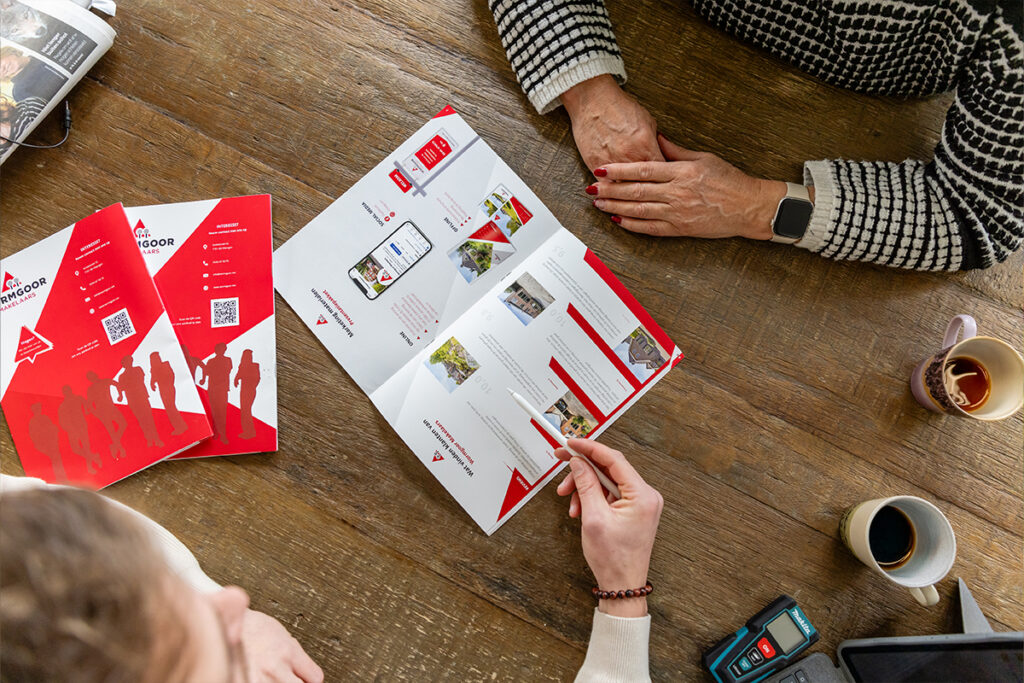 Overzicht van woninginformatie en brochures tijdens een gesprek bij Wormgoor Makelaars